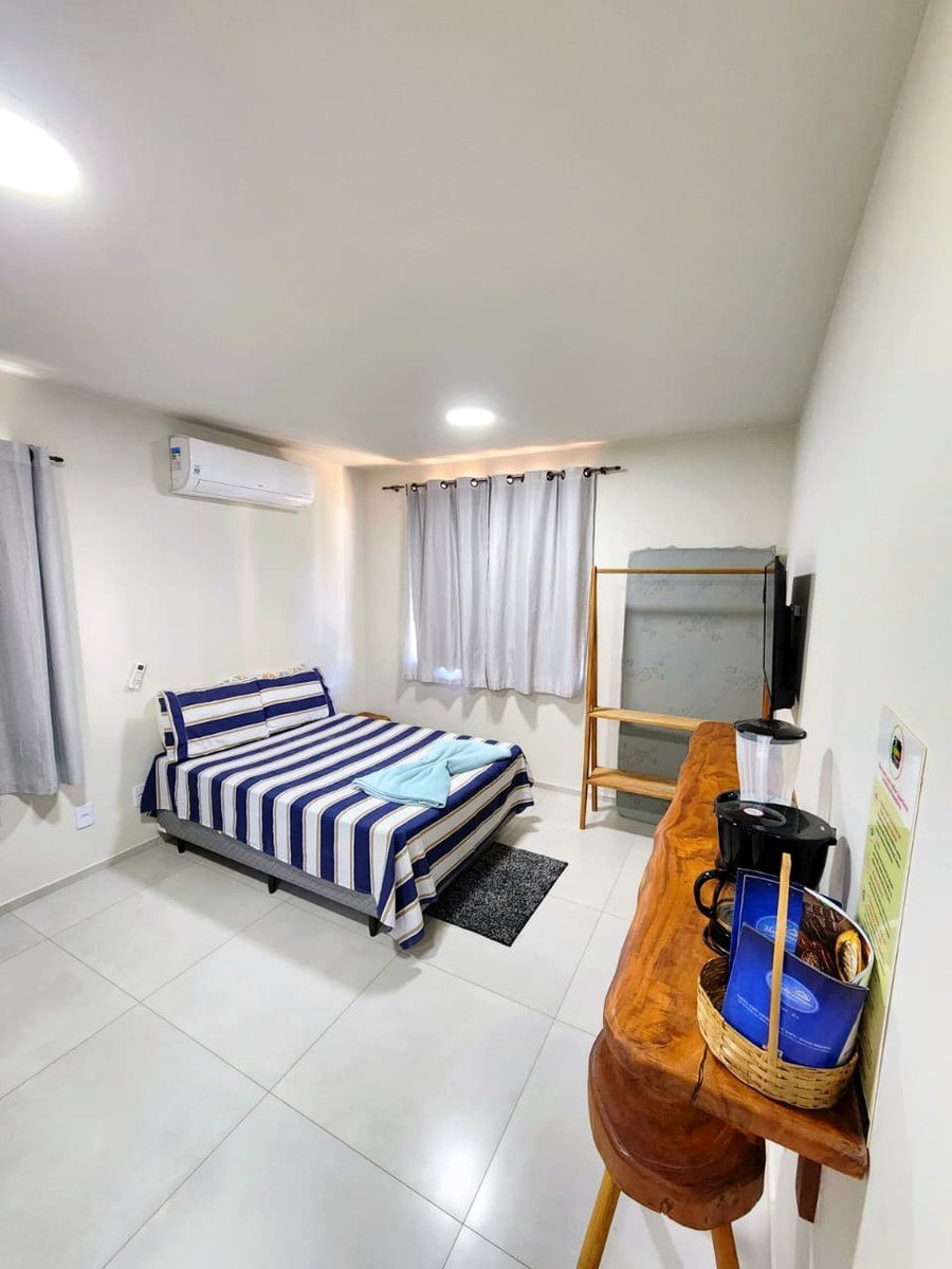 Quarto Resende com cama de casal, climatização e área de apoio